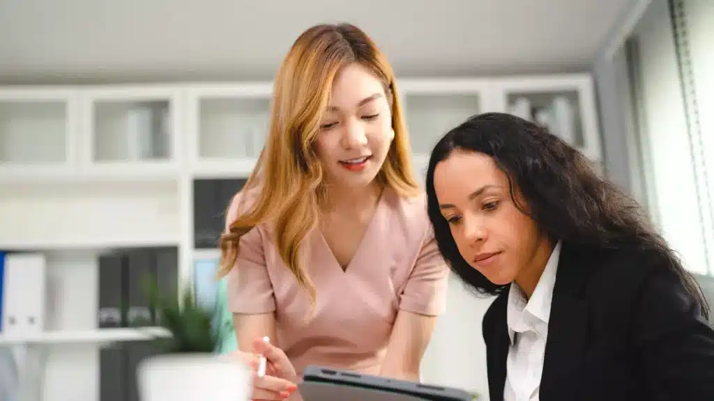 Two women in the office discussing work